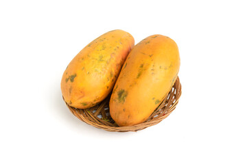 close up of whole orange yellow ripe papaya on plate isolated on white background