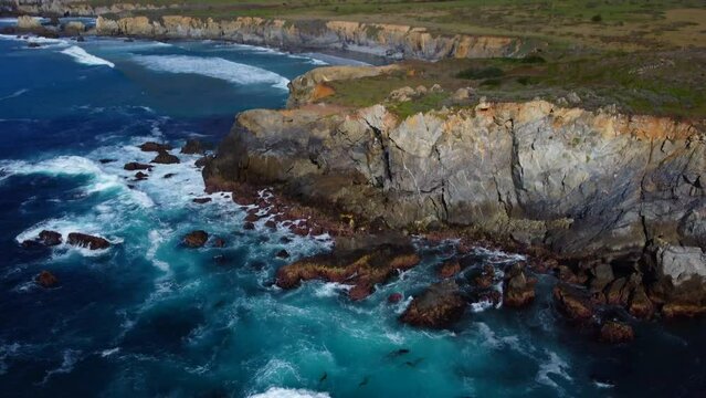 Aerial drone flying over Big Sur California coast beach. The ocean clouds sky sun sunny waves crashing. Travel view scene weather wave. Rocky formations. High quality 4k footage.