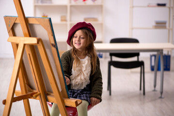 Young little girl enjoying painting at home