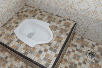 white squat toilet in bathroom. old style toilet. commonly used in asia