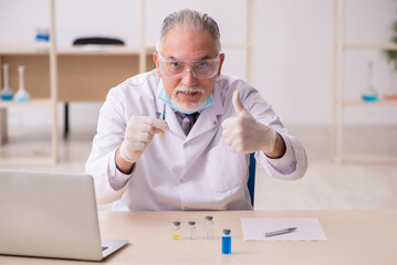 Old male chemist working in the lab during pandemic