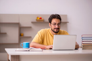 Young male student preparing for exams at home