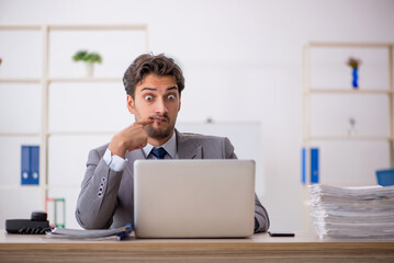 Young male employee sitting at workplace