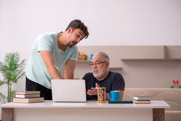 Grandfather and grandson at home with computer