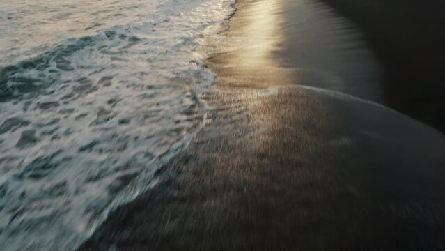 Foamy Waves Splashing On The Black Sand Beach Of El Paredon In Guatemala At Sunset - drone shot