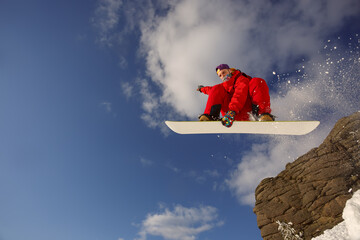 Snowboarder in a jump against the blue sky