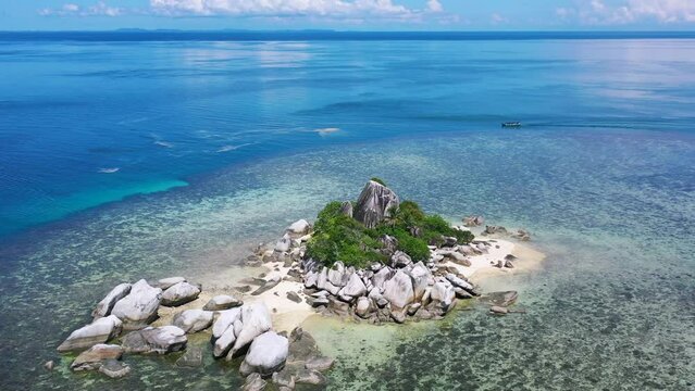 aerial of remote island in tropical waters with rocky beach in belitung indonesia