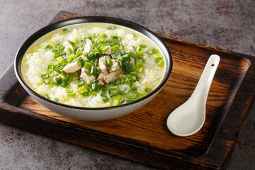 Dak Gomtang Korean Chicken Soup served with rice and green onion close-up in a bowl on the table. Horizontal