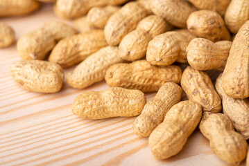 Close up shot of peanuts on wooden table. Golden peanut after roasting, fresh nuts