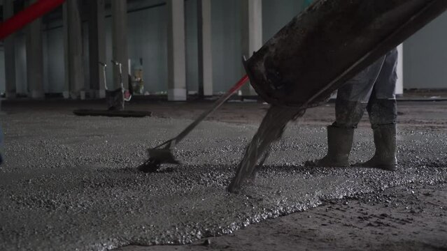 Pouring the concrete floor. Construction work inside of giant warehouse