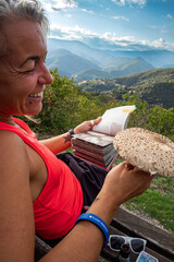 Mushroom forager identifying wild mushrooms with mushroom identification book in the mountain...
