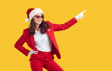 Cheerful joyful confident pretty Santa woman in disco party outfit, Xmas cap, white gloves and sun...