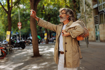 Fototapeta premium Caucasian senior man taking selfie in city.