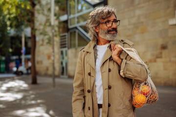Senior man with fruits on street.