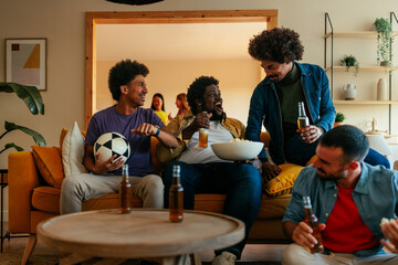 Friends bonding at home watching soccer.