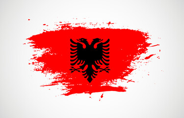 Grunge brush stroke with the national flag of Albania on a white isolated background