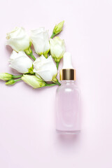Obraz na płótnie Canvas Natural essential oil, serum in a glass drop bottle on a pink background. Alternative medicine, aromatic herbal beauty skin care product. Minimal style, copy space, mockup