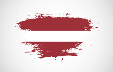 Grunge brush stroke with the national flag of Latvia on a white isolated background