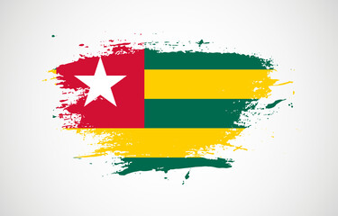 Grunge brush stroke with the national flag of Togo on a white isolated background
