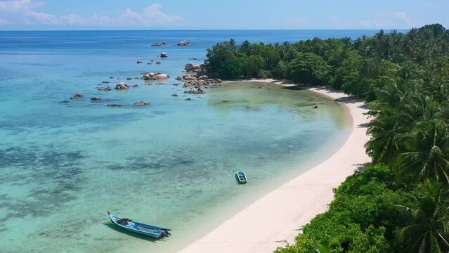 aerial of long white sand beach on tropical island on sunny summer day in belitung indonesia