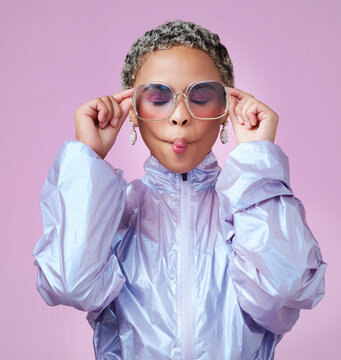 Fashion, beauty and lips with a black woman or model in sunglasses pouting in studio on a pink background. Trendy, style and edgy with an attractive, goofy female posing in contemporary clothes