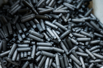 Grey shell casings in container at armor production plant
