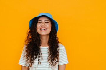 White curly woman wearing panama laughing while posing on camera