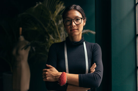 Portrait Of A Confident Female Fashion Designer Standing In Her Studio