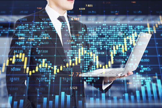 businessman hand holding laptop with creative forex chart with candlestick graph, index and tech hologram on blurry office interior background. Trade, stock, and finance concept. Double exposure.