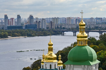 Fototapeta na wymiar The domes of the Kiev-Pechersk Lavra rise on the Dnieper River in the city of Kyiv 