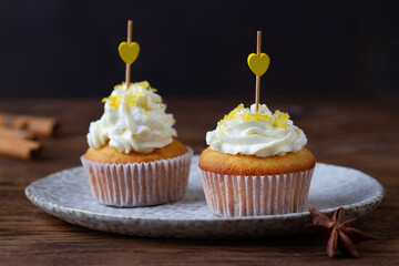 Pair of cupcakes with hearts on a dark background