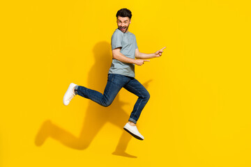 Fototapeta na wymiar Full length photo of positive funky man dressed trendy clothes arm presenting empty space isolated on yellow color background