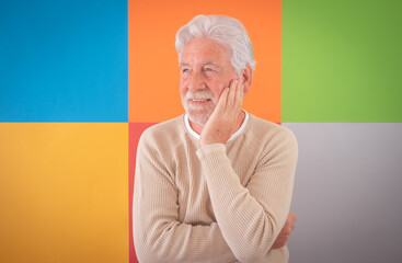 Adult handsome senior man smiling standing over colorful cute background. Caucasian 70 years old...