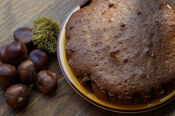 chestnut cake on wooden table with chestnuts nearby
 - Powered by Adobe