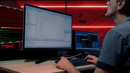 The man codes at a crazy pace in the Delphi programming language. Sometimes he stops at work and thinks. The lights of the servers can be seen in the background. - Powered by Adobe