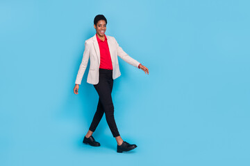 Full length profile portrait of confident person walking wear blazer isolated on blue color background