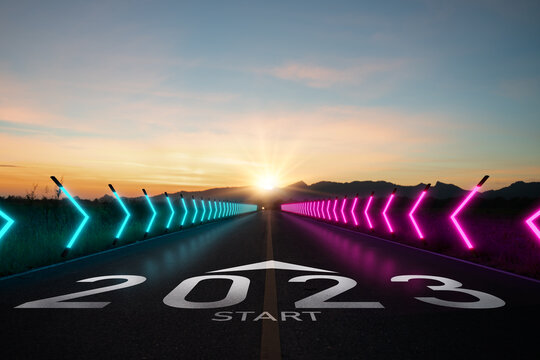 New year 2023 or start straight concept.word 2023 written on the road in the middle of asphalt road at sunset.Concept of planning and challenge or career path,business strategy,opportunity and change