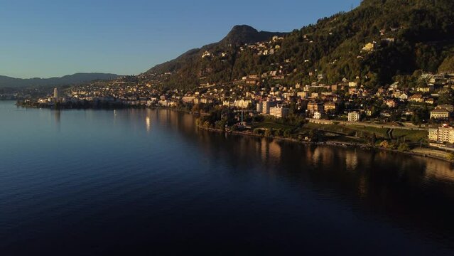 Fantastic aerial shot of the shore of Lake Leman, in the commune of Veytaux, in the canton of Vaud. You can see part of the city and during the golden hour.