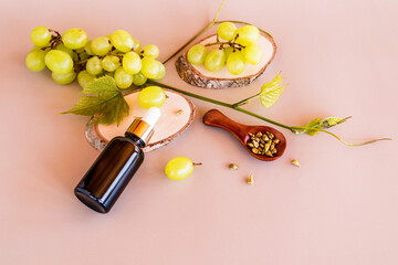 a cosmetic bottle made of dark glass with a dropper with a natural organic product based on grape seeds lies on a slice of wood. additional care.