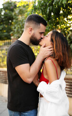 Happy young couple kissing on city street