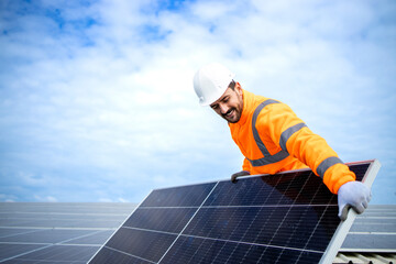 Installing solar power plant as sustainable energy source. Worker placing solar panel on the roof.