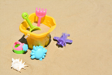 Set of plastic beach toys on sand, space for text