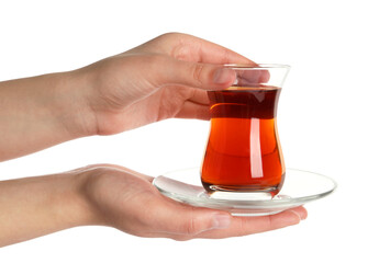 Woman holding glass of traditional Turkish tea with saucer on white background, closeup