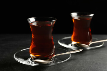 Glasses with traditional Turkish tea on black table