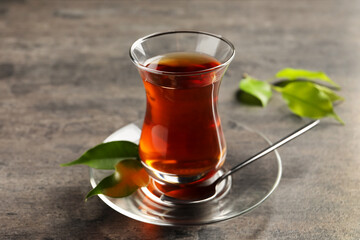 Glass with traditional Turkish tea on grey table
