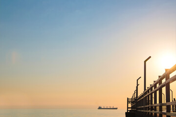 Picturesque view of pier near sea with boats at sunrise
