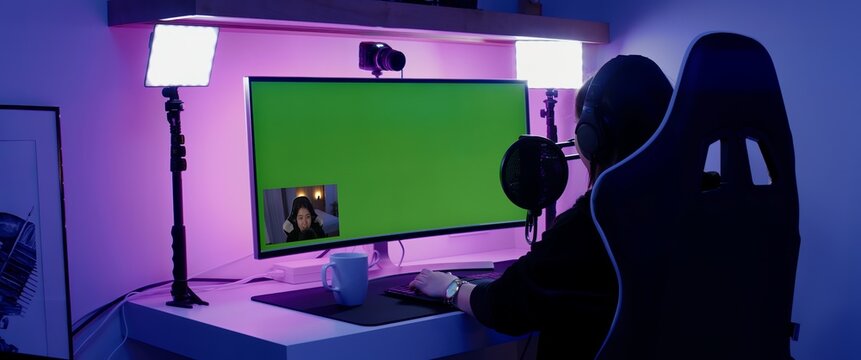 GREEN SCREEN CHORMA KEY Korean female gamer streamer putting on headphones, playing online games and streaming from home