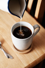 Coffee cup. Pouring milk in coffee mug, selective focus, morning hot drink. Lifestyle drink photo