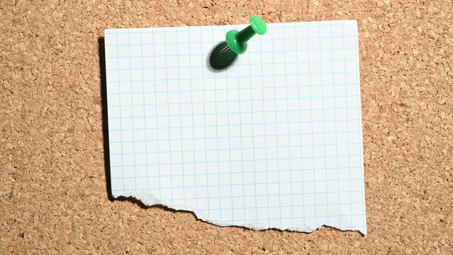 Papel recortado clavado con un pin de color verde en el tablero