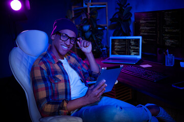 Profile photo of positive hacker sit chair use tablet operating research evening loft office...
